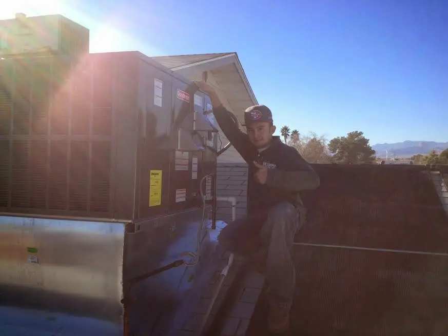 HVAC technician performing Air Duct Cleaning on a rooftop unit in East St. Louis